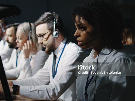 People with headsets looking nervously at their screens.